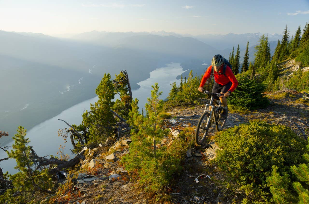A mountain biker rides high above Kootenay Lake in the Purcell Mountains of British Columbia
