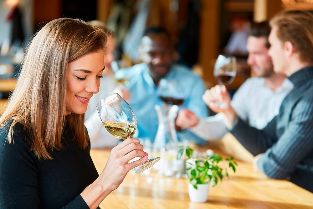 Woman is drinking a glass of wine on a wine tasting
