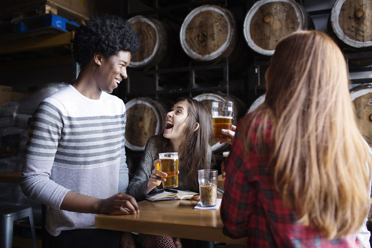 Smiling friends enjoying beer in brewery