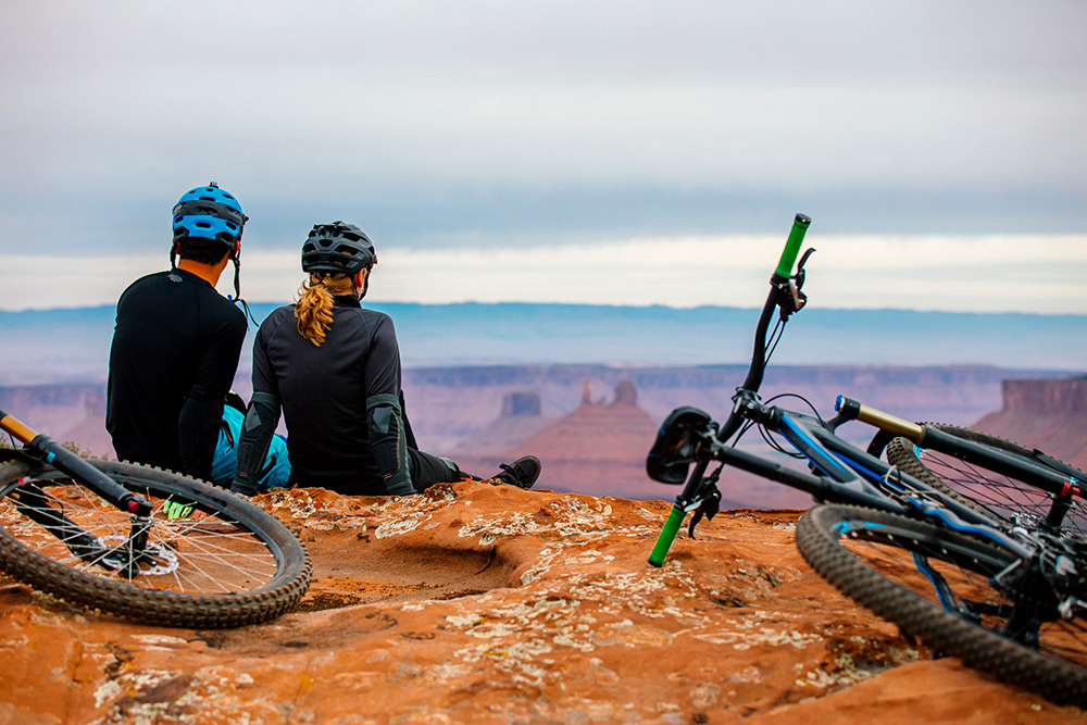 A Young Mountain Biking Couple Takes A Minute To Take In The Scenery