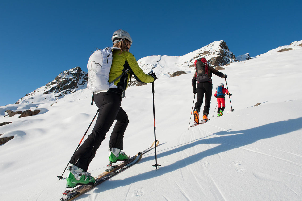Ski touring hiking uphill in the mountains.