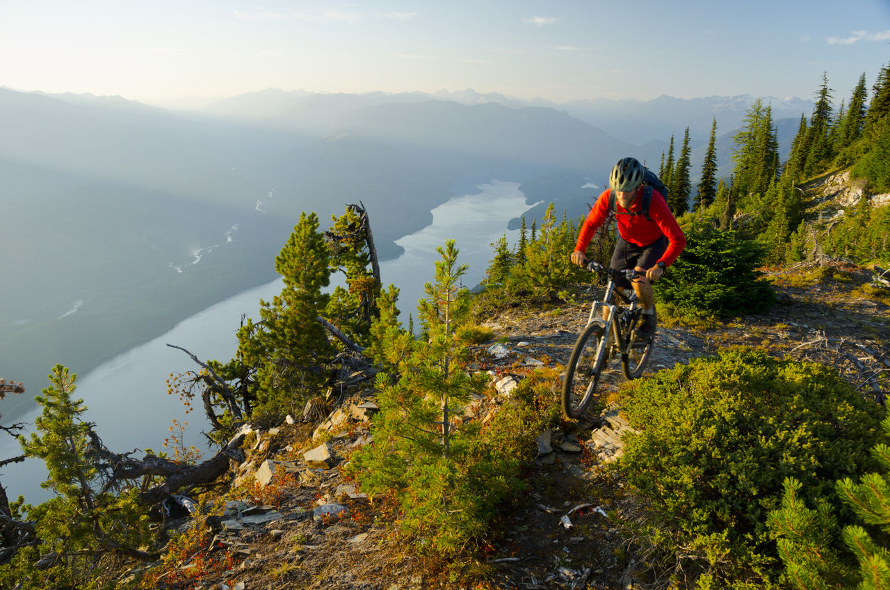 A mountain biker rides high above Kootenay Lake in the Purcell Mountains of British Columbia